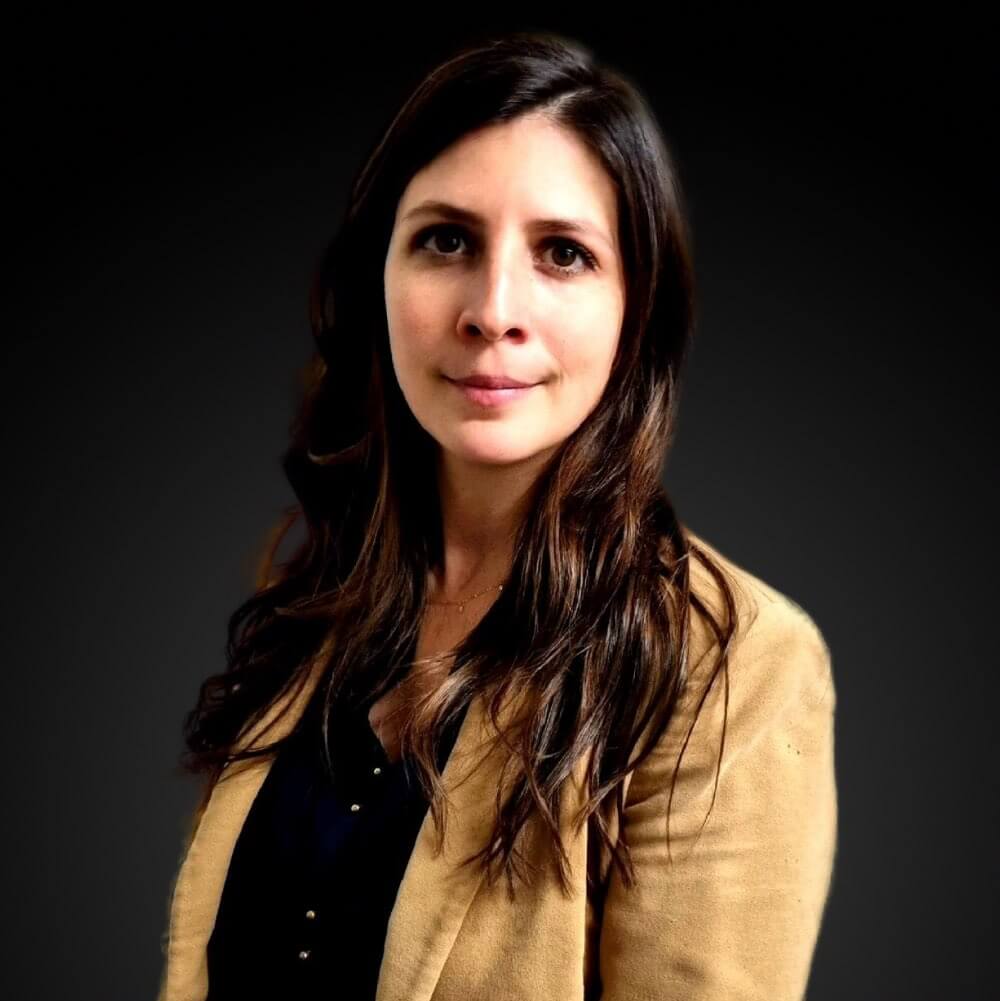 Femme en veste beige sur fond noir.