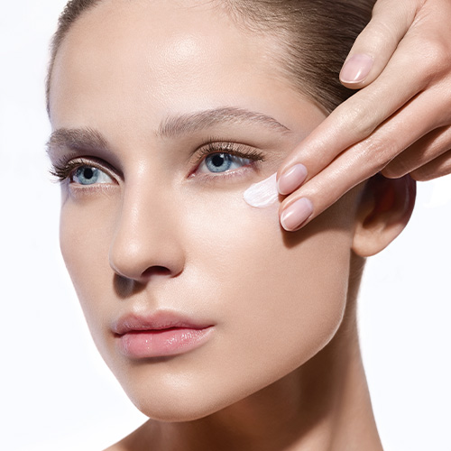 Application de crème hydratante sur le visage féminin.