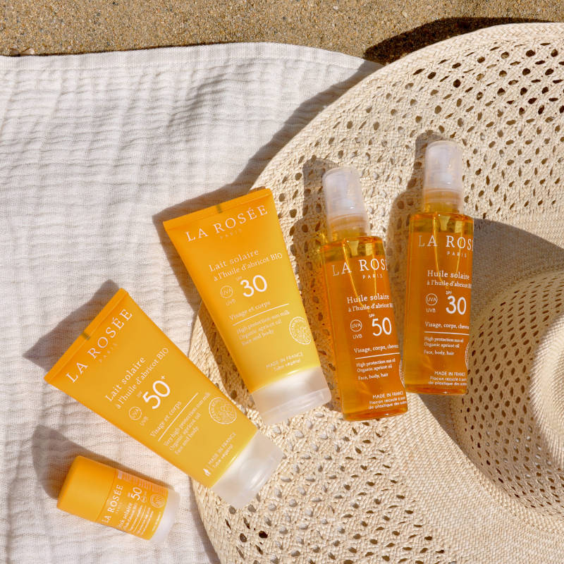 Produits solaires La Rosée sur serviette et chapeau.