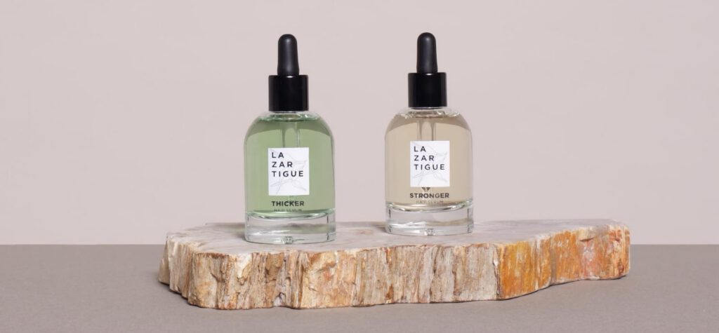 Deux sérums capillaires Lazartigue sur une tranche de bois.